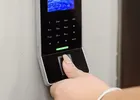 Show photo 1: A customer pressing a finger on the wall-mounted Paznic biometric reader