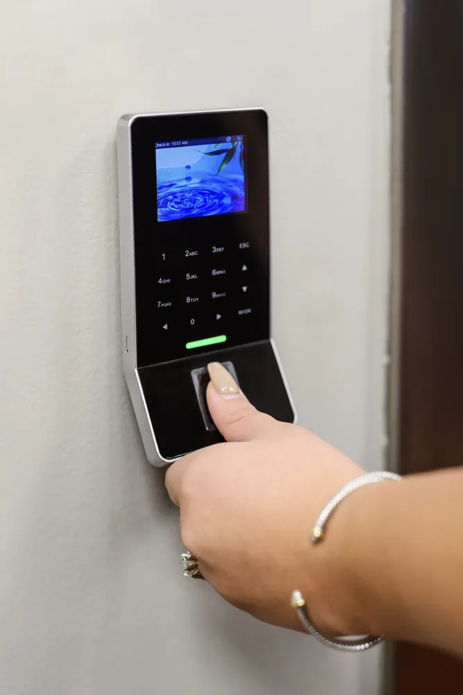 A customer pressing a finger on the wall-mounted Paznic biometric reader