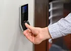 Show photo 8: A customer pressing a finger on the biometric reader beside the vault entrance
