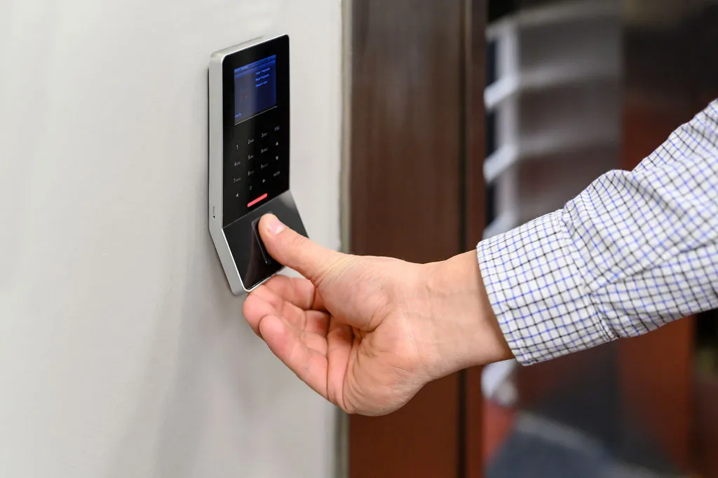 A customer pressing a finger on the biometric reader beside the vault entrance