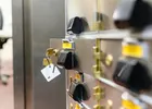 Show photo 12: A safe deposit box door standing open with the key and tag still in the lock