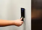 Show photo 14: A hand on the fingerprint reader mounted beside the wooden vault door frame